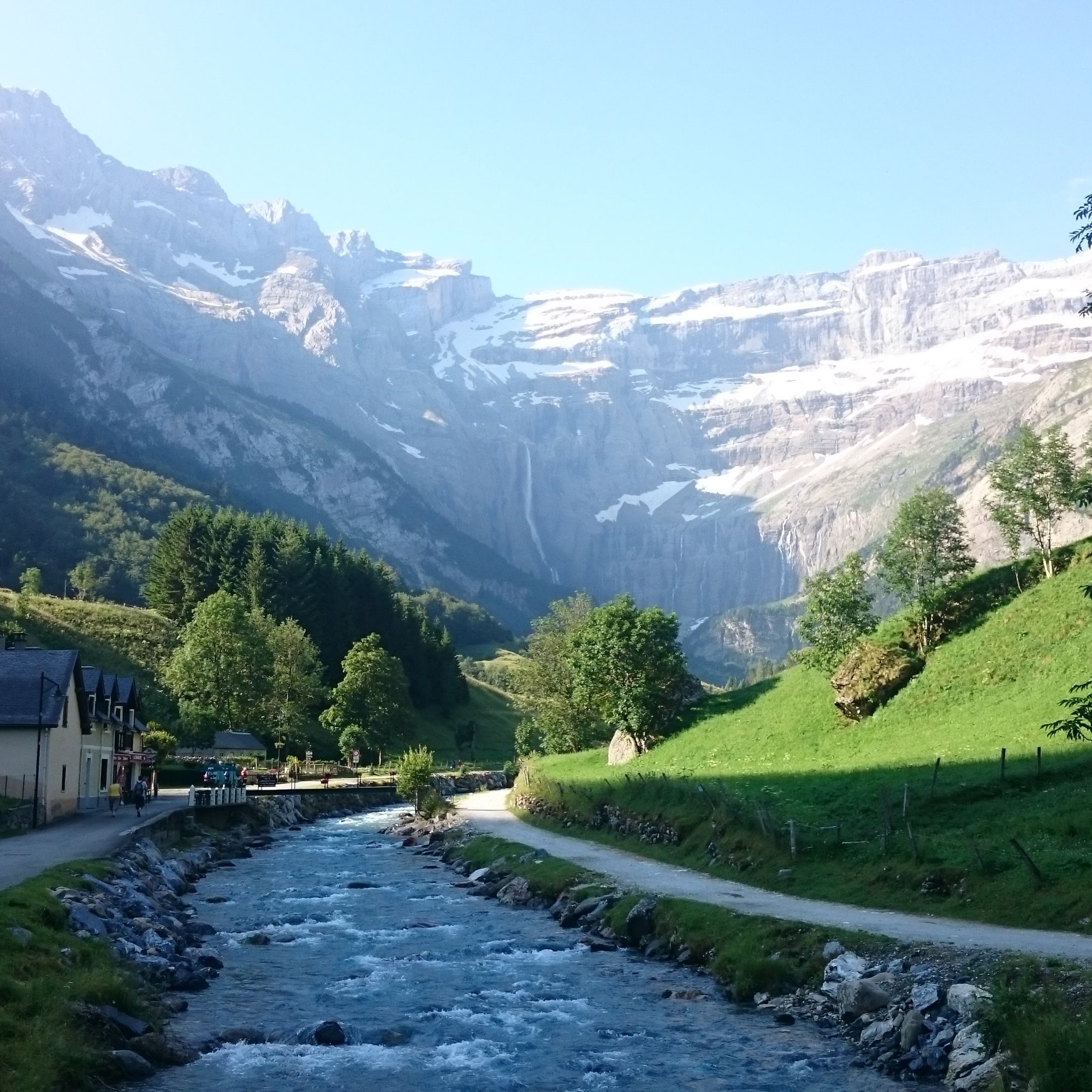 A mountain village beside a rushing stream, opening onto a glacial cirque