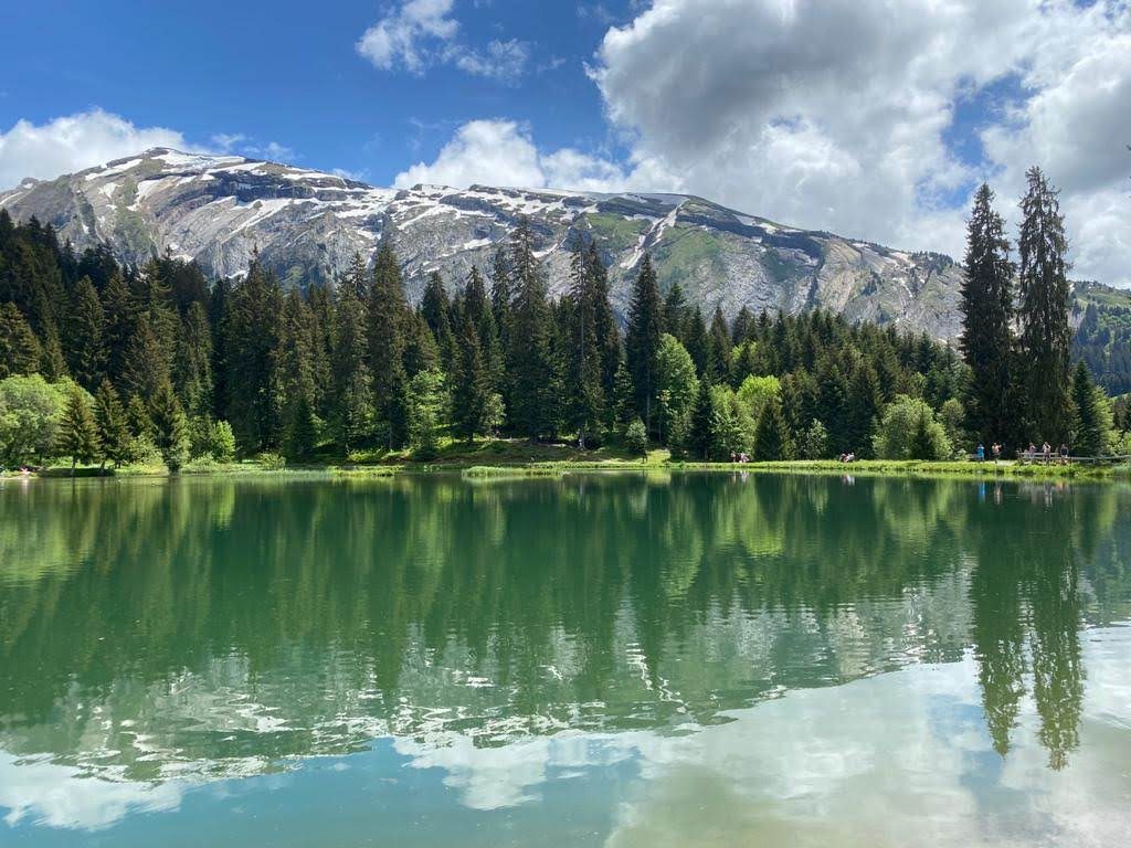 A clear alpine lake reflecting a snow-capped mountain